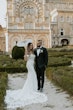 Bride wearing Cecilia by Rebecca Ingram holding a parasol with her husband