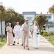 Bride wearing Davis Leigh wedding dress by Sottero and Midgley walking with her husband