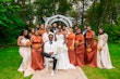 Bride Wearing Simple Fit and Flare Wedding Dress Called Anniston Lane With Bridal Party In Orange And Cream Outfits