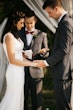 Bride with groom wearing satin sheath wedding dress.