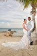 Bride wearing Franklynn by Sottero and Midgley with her husband near a palm tree