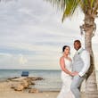 Bride wearing Franklynn by Sottero and Midgley with her husband near a palm tree