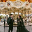 Bride Wearing Black Lace Wedding Dress Called Zander Lane By Sottero And Midgley With Groom Standing In Front Of A Moving Carousel