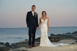 Groom Holding Hands with Bride in Front of Ocean Wearing Mermaid Wedding Dress called Tuscany by Maggie Sottero.