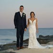 Groom Holding Hands with Bride in Front of Ocean Wearing Mermaid Wedding Dress called Tuscany by Maggie Sottero.