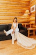 Bride Wearing Keyhole Back Halter Wedding Dress Called Bellarose By Rebecca Ingram Putting On Long White Boots