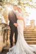 Bride Wearing Glamorous Lace And Sequin Wedding Dress Called Tuscany By Maggie Sottero Posing With Groom In Sunlight