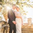 Bride Wearing Glamorous Lace And Sequin Wedding Dress Called Tuscany By Maggie Sottero Posing With Groom In Sunlight