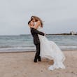 Bride Wearing Beaded Fit-n-flare Wedding Dress Called Jonah Lane By Sottero And Midgley With Groom On The Beach