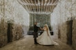 Bride Wearing Sparkly Aline Wedding Dress Called Anniston With Groom And Lights Hanging Throughout The Room