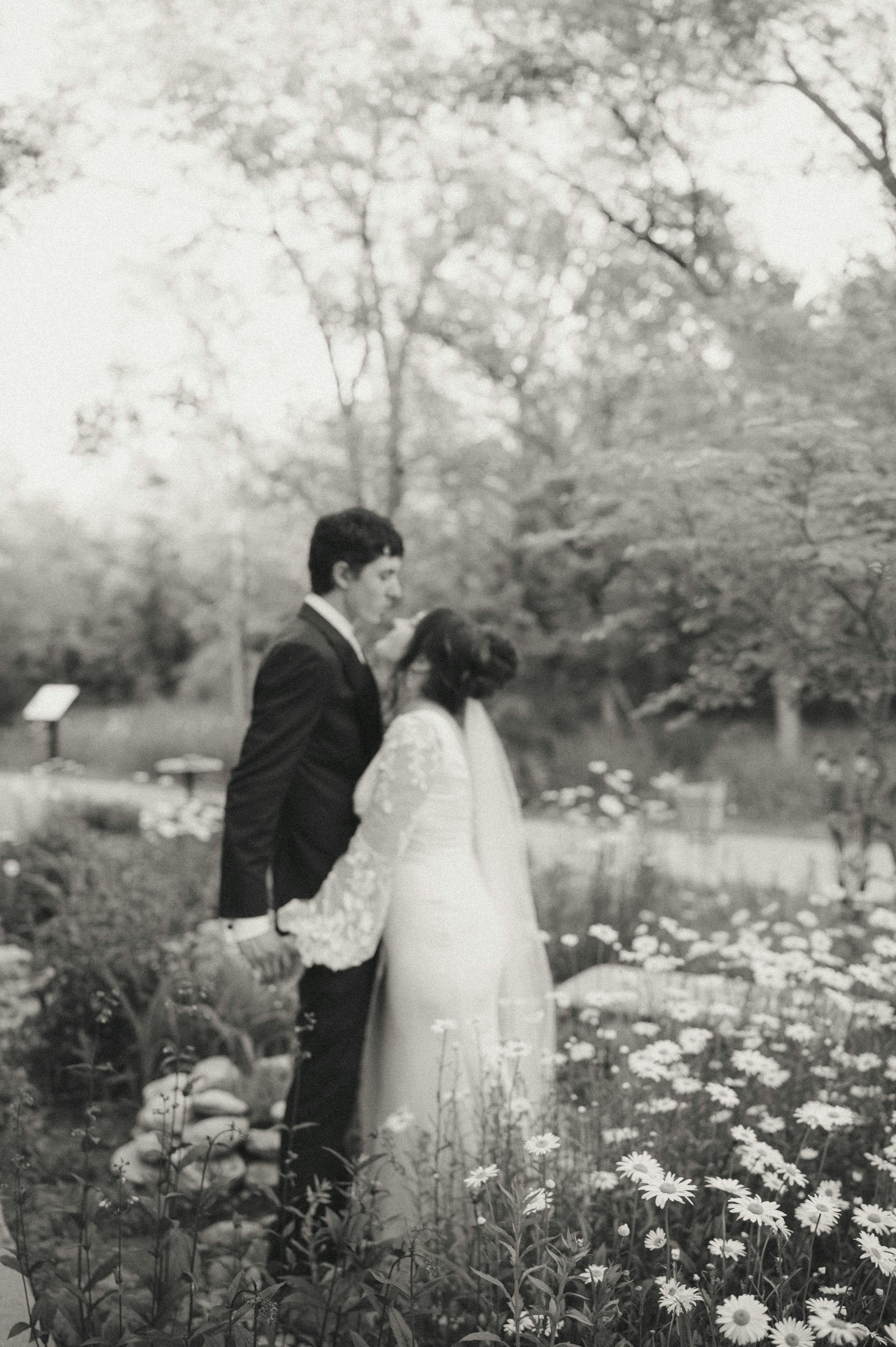 Bride Wearing Simple Long Sleeve Wedding Dress Called Iliana By Rebecca Ingram With Groom In A Garden