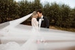 Groom with Bride in VIntage Inspired Puff Sleeve Mermaid Wedding Dress in 3-D Floral Motifs Called Cruz by Sottero & Midgley