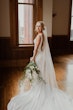 Bride wearing simple sheath wedding dress with V-neck.