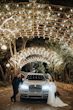 Groom and Bride Wearing A-line Bridal Dress Ainsleigh By Rebecca Ingram Next To A Limo