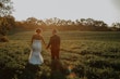 Bride wearing Marguerite wedding dress by Maggie Sottero holding hands with her husband