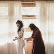 Bride Wearing Lacey Sheath Long Sleeve Wedding Dress Called Francesca By Maggie Sottero Getting Ready Doing Buttons