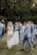 Bride wearing Scarlet by Maggie Sottero kissing her husband surrounded by their wedding party