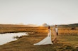 Bride Wearing Keyhole Back Halter Wedding Dress Called Bellarose By Rebecca Ingram Walking With Groom