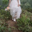 Bride wearing Winter wedding dress by Maggie Sottero hikes in tennis shoes