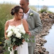 Bride Wearing Simple Chiffon Wedding Dress Called Marta Lynette By Rebecca Ingram Holding Bouquet With Groom On Rocky Beach
