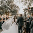 Bride And Groom At The Altar. Bride Wearing Romantic Long Sleeve Boho Ball Gown Called Mallory Dawn By Maggie Sottero