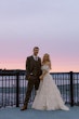 Bride wearing Laila wedding dress by Maggie Sottero standing with her husband