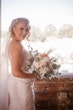 Bride Wearing Classic Elegant Wedding Dress Called Sebastiane By Maggie Sottero Holding Flower Bouquet By Window