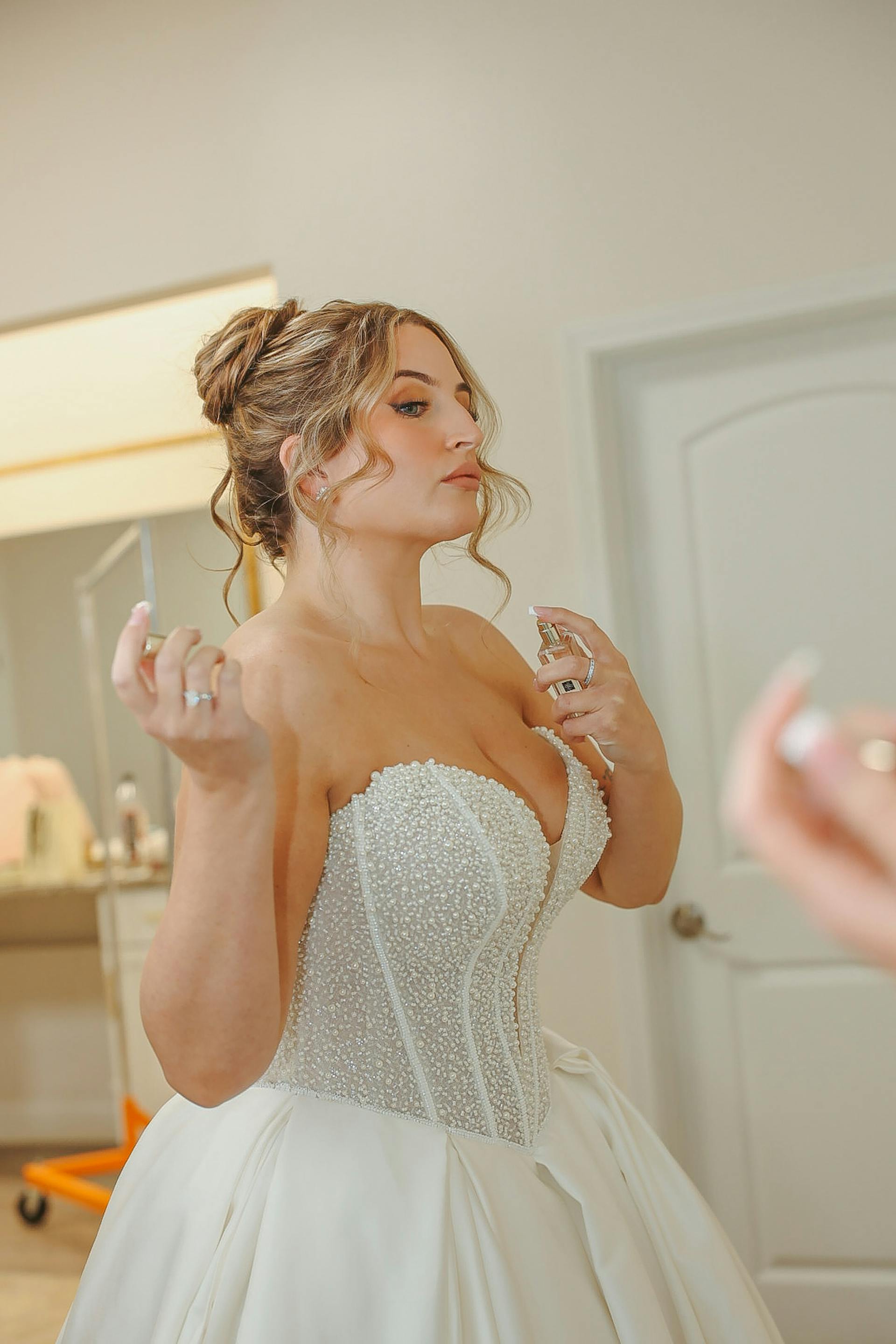 Bride Wearing Beaded Ballgown Wedding Dress Called Tina By Maggie Sottero Putting On Perfume