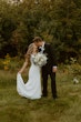 Bride Wearing Simple Fit-and-Flare Wedding Dress Called Fernanda By Maggie Sottero Kissing Groom