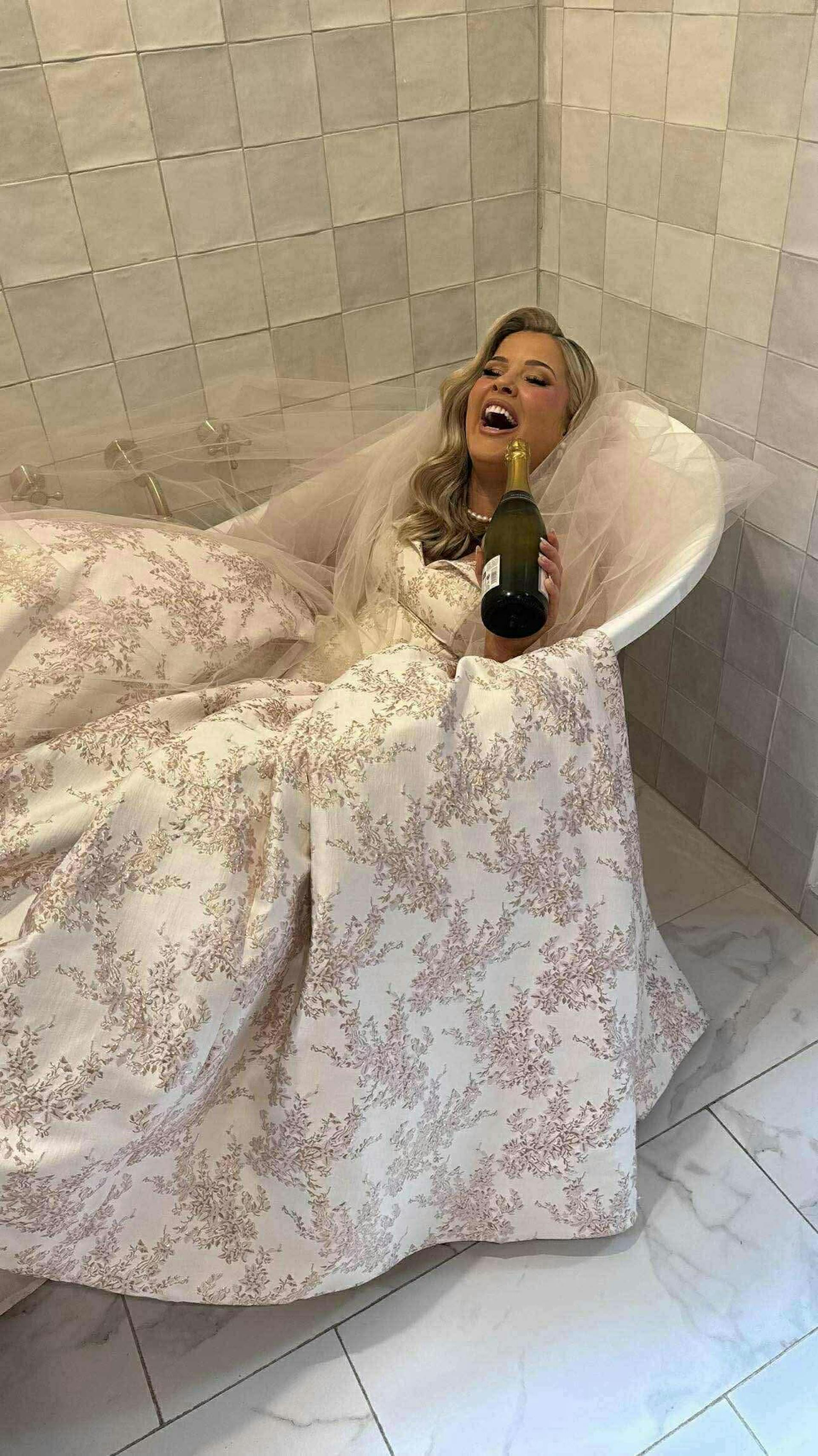 Bride Wearing Pink Lace Wedding Dress Called Aberdeen By Sottero And Midgley Laying In A Bathtub Drinking Champagne