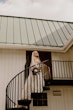 Bride Wearing Square Neck Long Sleeve Floral Wedding Dress Called Sawyer By Sottero And Midgley With Bouquet On Balcony