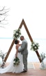 Bride Wearing Simple Chiffon Wedding Dress Called Marta Lynette By Rebecca Ingram Together With Groom Under Triangle Arch