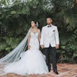 Bride with groom wearing glamorous mermaid wedding dress
