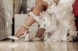 Bride wearing Ryker wedding dress by Sottero and Midgley showing off shoes and garter