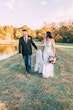 Bride Wearing Crepe Sheath Wedding Dress Called Alda By Rebecca Ingram Walking With Groom