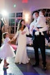 Bride wearing Fernanda wedding dress by Maggie Sottero dancing with her family