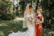 Bride wearing Marguerite wedding dress by Maggie Sottero with a flower girl