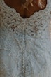 detail of lace wedding dress and clear buttons.