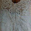 detail of lace wedding dress and clear buttons.