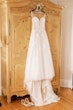 Boho Sheath Wedding Dress Called Marisol By Rebecca Ingram Hanging From An Armoir