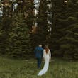 Newlyweds walking towards the woods together.