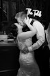 Bride Wearing Rustic Lace Wedding Dress Called Larkin Lynette By Rebecca Ingram Kissing Groom With A Neon Sign That Says The Talds
