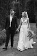 Bride wearing Paxton by Maggie Sottero walking with her husband while holding hands