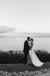 Bride Wearing Sexy Strapless Wedding Dress Called Zelda By Rebecca Ingram Kissing Groom At The Lake