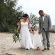 Bride Wearing Simple Chiffon Wedding Dress Called Marta Lynette By Rebecca Ingram Walking With Groom And Flower Girl On Beach