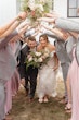 Bride Wearing Lace Beaded Wedding Dress Called Charmaine By Maggie Sottero And Groom Walking Through Their Bridal Party Bridge