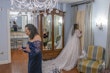 Bride wearing Seneca wedding dress by Sottero and Midgley looking out the window