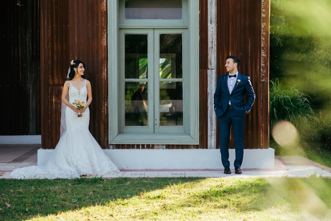 Bride With Groom Outside a Barn Wearing Wedding Gown Called Giana Lynette by Maggie Sottero