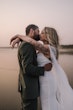 Bride wearing Summer wedding dress by Maggie Sottero kissing the groom