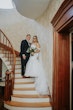 Bride wearing Danielle by Maggie Sottero with her husband on the stairs